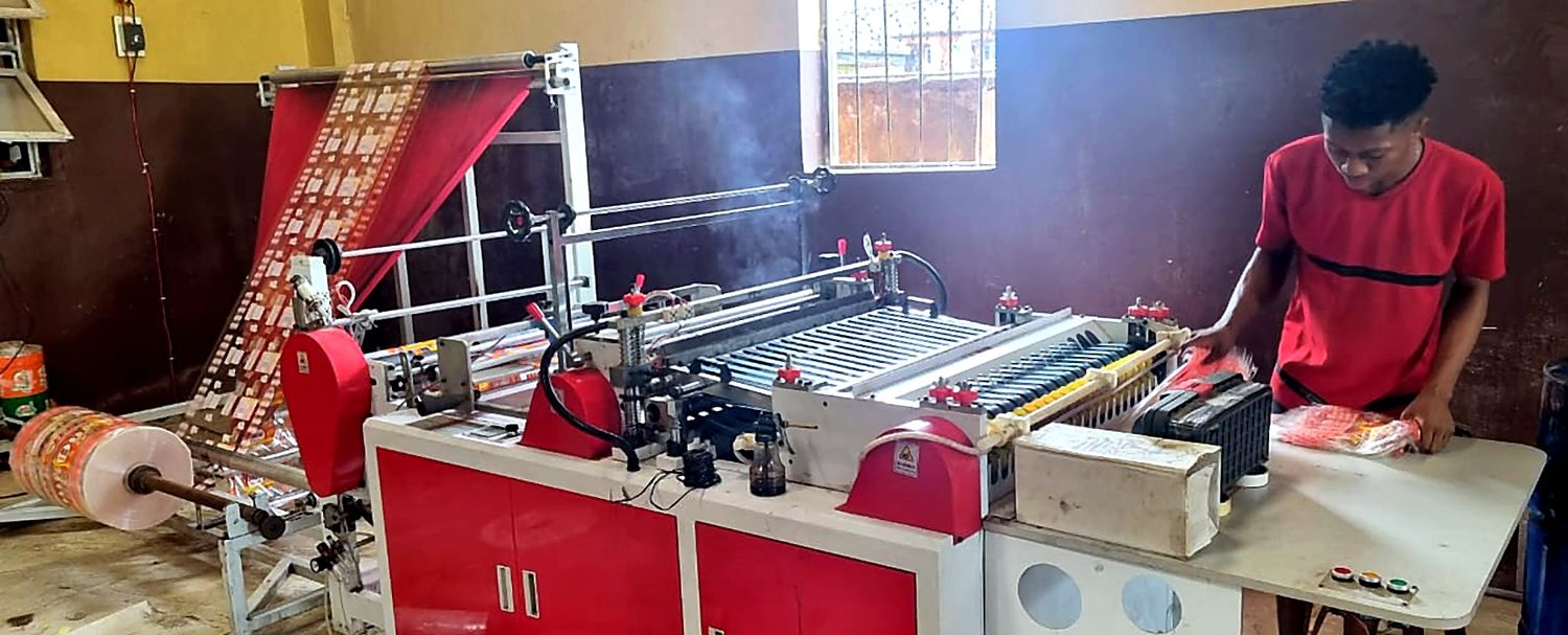 A Mimshak Pak operator running a packaging machine in Asaba